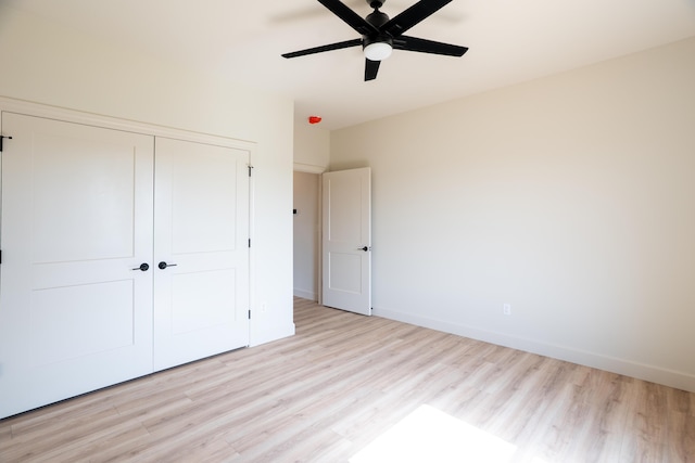 unfurnished bedroom with a closet, a ceiling fan, light wood-style flooring, and baseboards