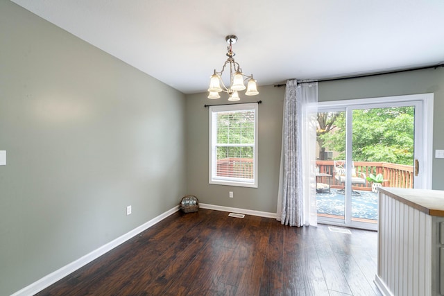 5003 Chesapeake Ln, Columbia, MO 65202 - unfurnished dining area featuring dark wood finished floors, baseboards, and a chandelier