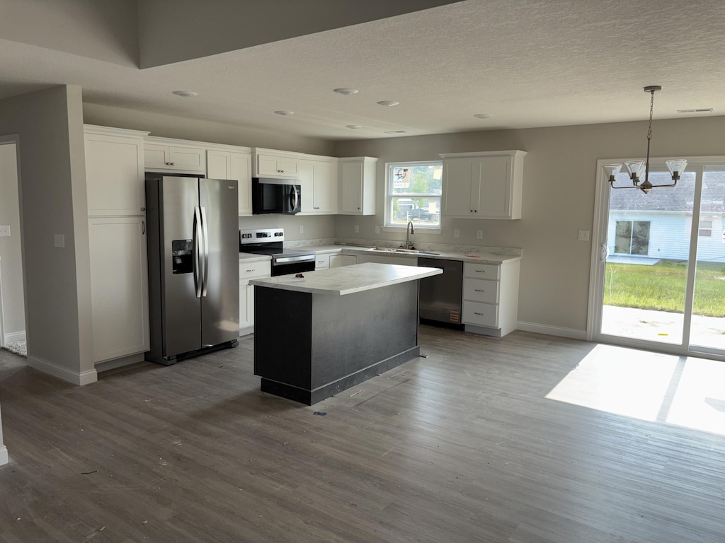2312 Bitternut Ct, Columbia, MO 65201 - kitchen featuring appliances with stainless steel finishes, a chandelier, baseboards, a kitchen island, and dark wood-style flooring