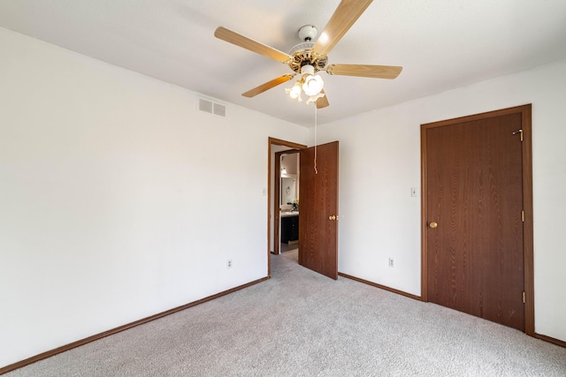 unfurnished bedroom with baseboards, carpet flooring, visible vents, and a ceiling fan