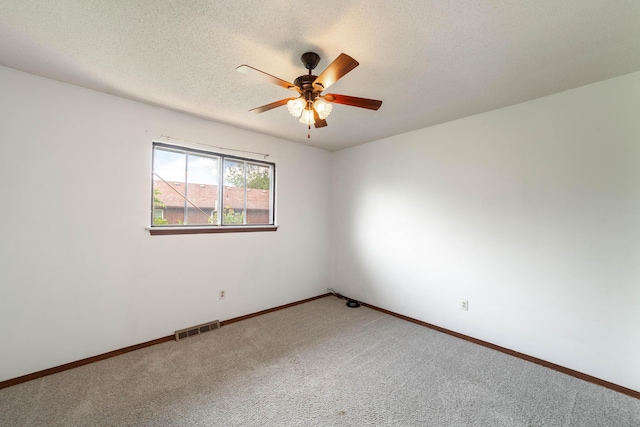 spare room featuring carpet flooring, a textured ceiling, visible vents, baseboards, and ceiling fan