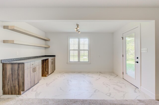 bar with baseboards and marble finish floor