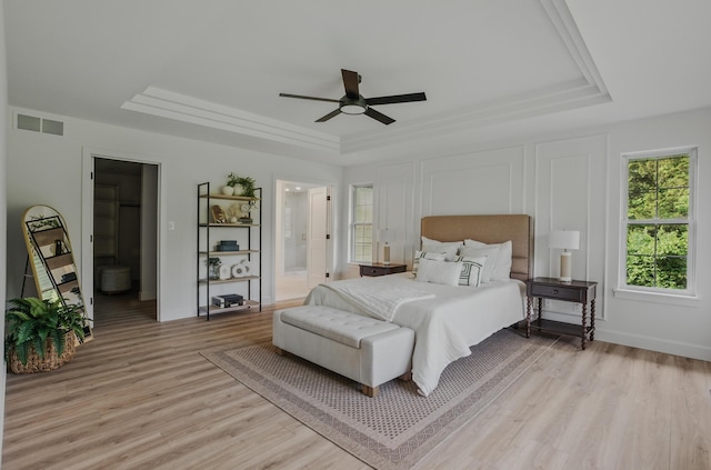 9747 S Rte N, Columbia, MO 65203 - bedroom with a tray ceiling, light wood-style flooring, ensuite bath, baseboards, and a ceiling fan
