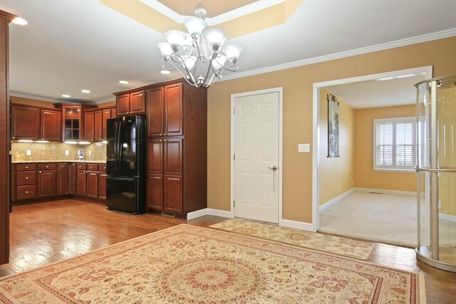 1204 S Walnut Ave, Salisbury, MO 65281 - kitchen featuring freestanding refrigerator, glass insert cabinets, a chandelier, light countertops, and baseboards