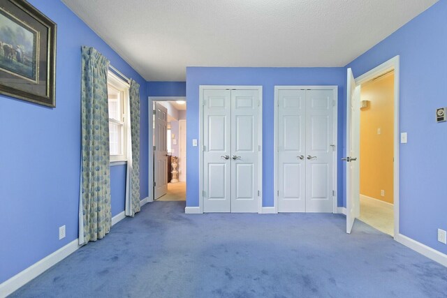 1204 S Walnut Ave, Salisbury, MO 65281 - unfurnished bedroom with two closets, baseboards, and carpet floors