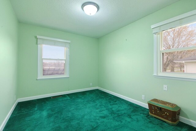 1204 S Walnut Ave, Salisbury, MO 65281 - empty room with dark colored carpet, a textured ceiling, and baseboards