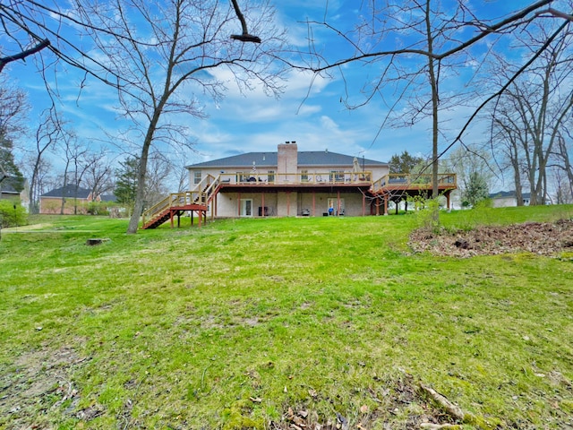 back of property with stairway, a wooden deck, a chimney, and a lawn