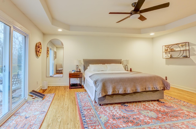 bedroom with access to outside, baseboards, light wood-type flooring, and arched walkways