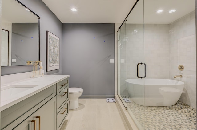 bathroom featuring vanity, recessed lighting, toilet, a shower stall, and a freestanding bath