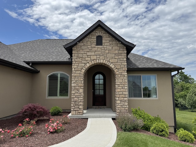 5005 Kiawah Ln, Columbia, MO 65203 - view of exterior entry featuring stone siding, roof with shingles, and stucco siding