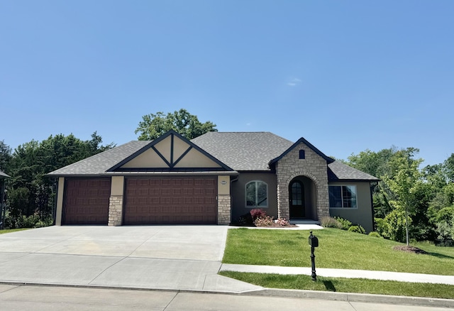 5005 Kiawah Ln, Columbia, MO 65203 - view of front of property with stone siding, a front lawn, stucco siding, a garage, and driveway