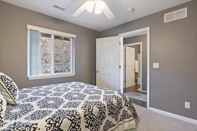 carpeted bedroom with visible vents, baseboards, ceiling fan, and a textured wall