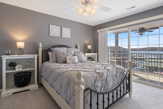 bedroom featuring visible vents, ceiling fan, carpet flooring, a water view, and access to exterior