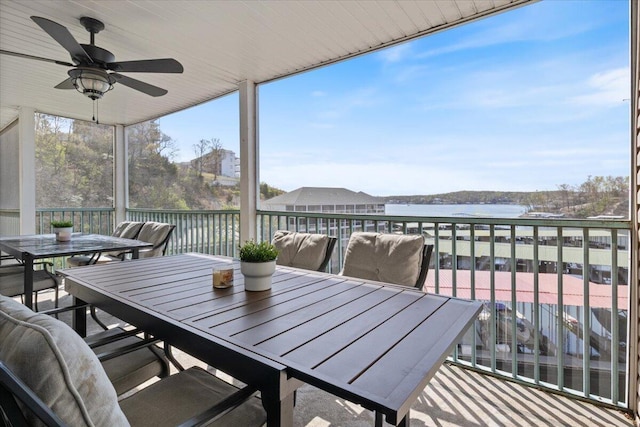 sunroom / solarium featuring ceiling fan, a water view, and outdoor dining area