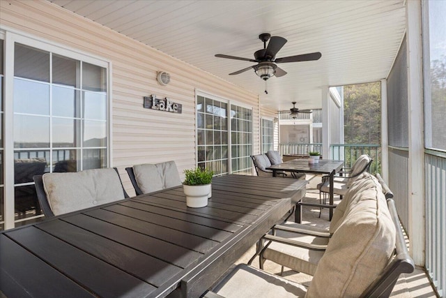 sunroom featuring outdoor dining space and a ceiling fan