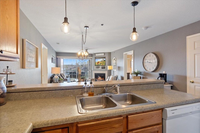 kitchen featuring white dishwasher, open floor plan, a sink, and decorative light fixtures