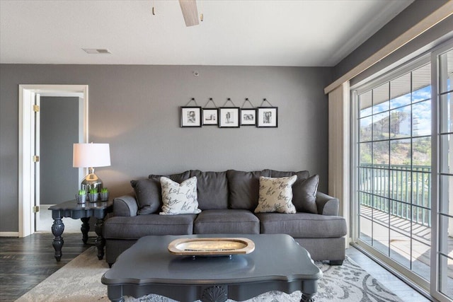 living area featuring visible vents and wood finished floors