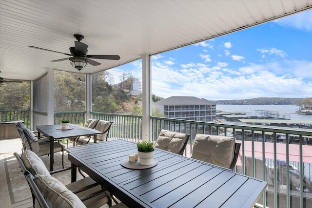 deck featuring a water view, a ceiling fan, and outdoor dining space