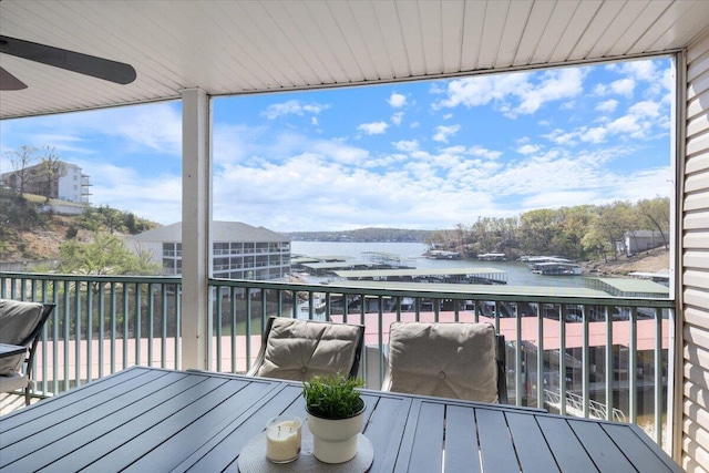 wooden terrace featuring a water view and outdoor dining area
