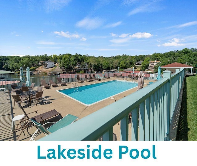 community pool with fence and a patio area