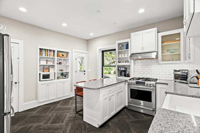 608 Westmount Ave, Columbia, MO 65203 - kitchen featuring appliances with stainless steel finishes, under cabinet range hood, a sink, a peninsula, and white cabinetry