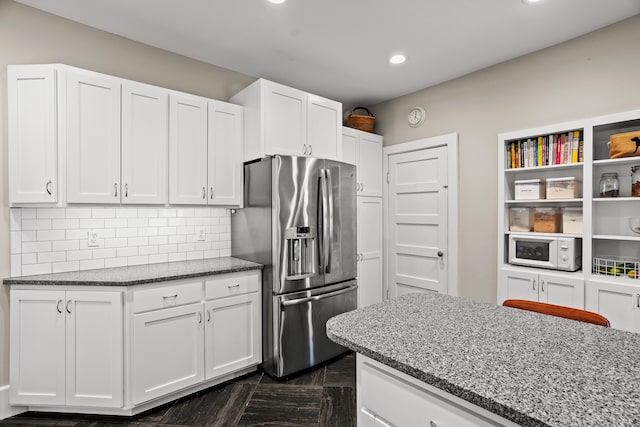 608 Westmount Ave, Columbia, MO 65203 - kitchen featuring stainless steel fridge with ice dispenser, white microwave, recessed lighting, dark stone counters, and white cabinetry