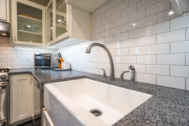 608 Westmount Ave, Columbia, MO 65203 - kitchen with a sink, tasteful backsplash, glass insert cabinets, stainless steel range, and dark stone counters