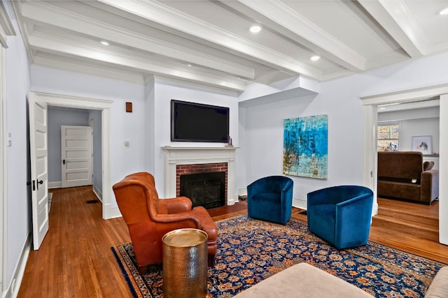 608 Westmount Ave, Columbia, MO 65203 - living area with beamed ceiling, wood finished floors, a brick fireplace, ornamental molding, and baseboards