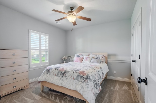 carpeted bedroom featuring a closet, baseboards, and a ceiling fan