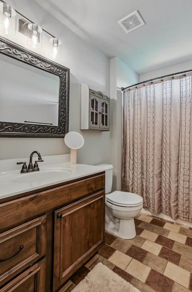 bathroom with toilet, vanity, visible vents, and a shower with curtain