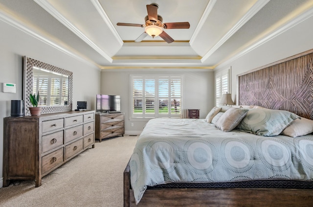 bedroom with a raised ceiling, crown molding, ceiling fan, and light carpet