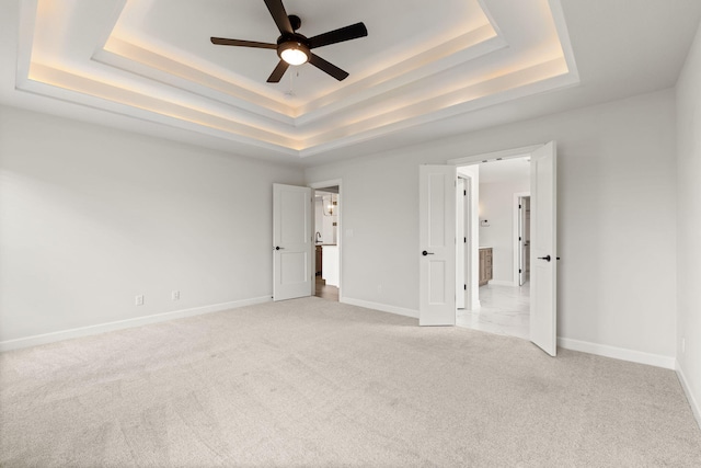 2816 Rivington Dr, Columbia, MO 65203 - unfurnished bedroom featuring a raised ceiling, light colored carpet, and a ceiling fan