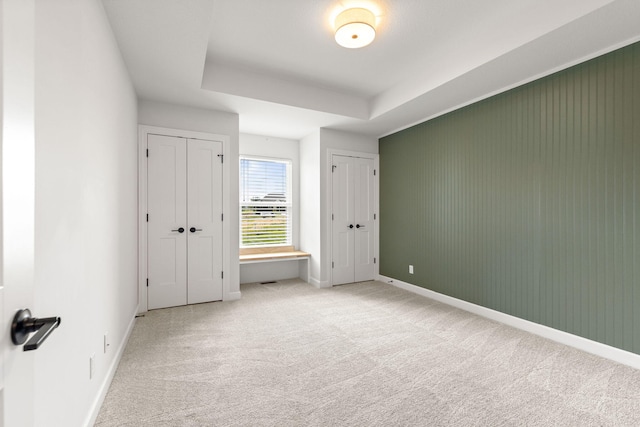 2816 Rivington Dr, Columbia, MO 65203 - unfurnished bedroom featuring light carpet, two closets, and a tray ceiling