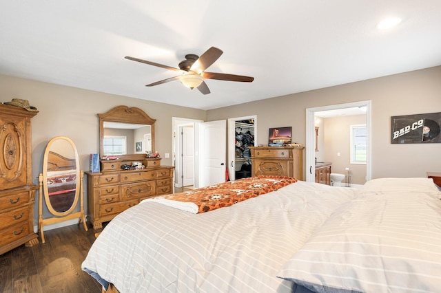 bedroom with ceiling fan, connected bathroom, dark wood-type flooring, a closet, and a spacious closet