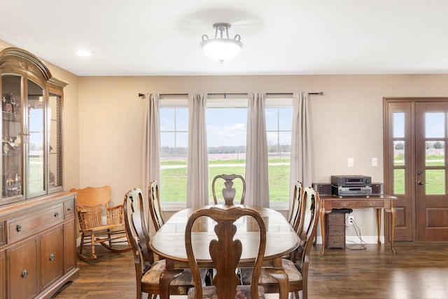 dining room featuring a healthy amount of sunlight, dark wood-style flooring, baseboards, and recessed lighting