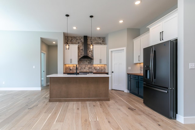 700 Brockton Dr, Columbia, MO 65201 - kitchen featuring black refrigerator with ice dispenser, wall chimney range hood, white cabinets, backsplash, and recessed lighting
