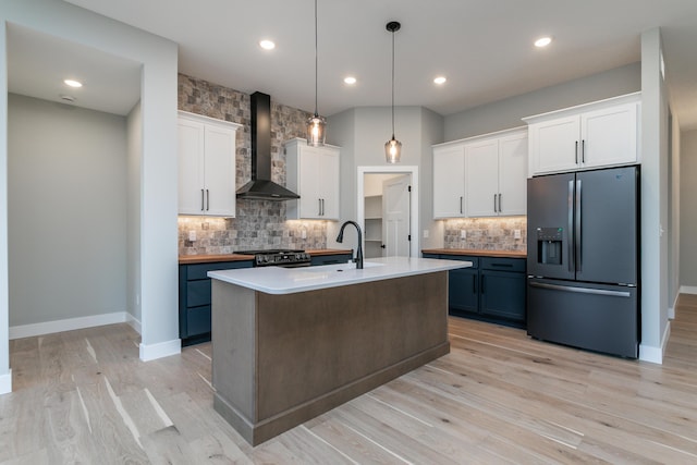 700 Brockton Dr, Columbia, MO 65201 - kitchen featuring stainless steel refrigerator with ice dispenser, wall chimney exhaust hood, backsplash, white cabinets, and recessed lighting