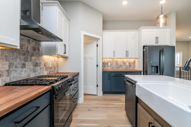 700 Brockton Dr, Columbia, MO 65201 - kitchen featuring wall chimney exhaust hood, wood counters, black appliances, white cabinets, and backsplash