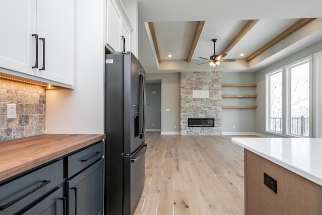 700 Brockton Dr, Columbia, MO 65201 - kitchen featuring black fridge with ice dispenser, light wood-type flooring, white cabinets, ceiling fan, and backsplash