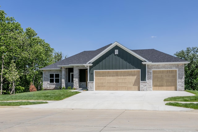 700 Brockton Dr, Columbia, MO 65201 - view of front facade with an attached garage, concrete driveway, a front lawn, stone siding, and board and batten siding