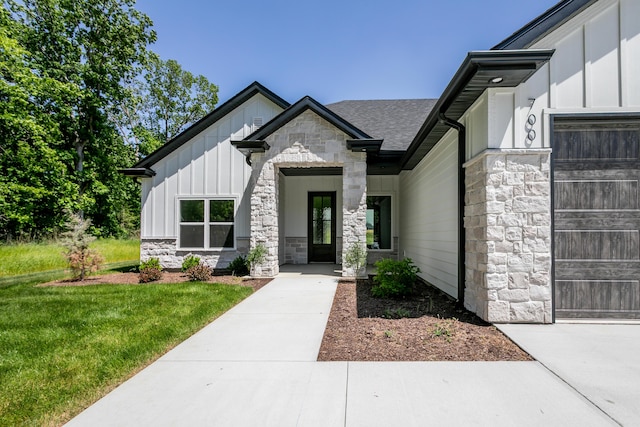 700 Sagemoor Dr, Columbia, MO 65201 - view of front of home with board and batten siding, stone siding, an attached garage, a front yard, and a shingled roof
