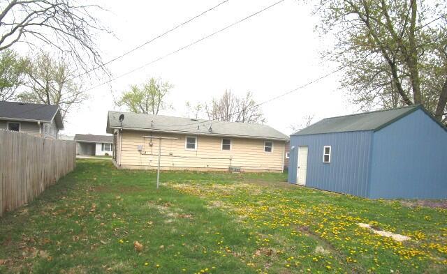 614 S Central St, Centralia, MO 65240 - rear view of property featuring a yard, fence, an outdoor structure, and a shed