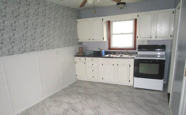 614 S Central St, Centralia, MO 65240 - kitchen featuring ceiling fan, dark countertops, a sink, electric stove, and wallpapered walls