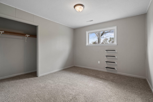 unfurnished bedroom with baseboards, a closet, visible vents, and carpet