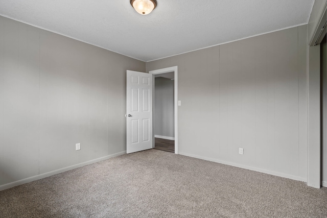 empty room with baseboards, ornamental molding, and carpet