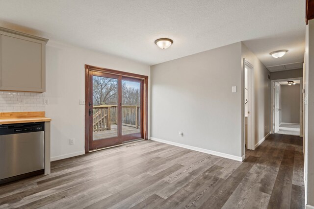 unfurnished dining area featuring attic access, baseboards, and dark wood-style floors