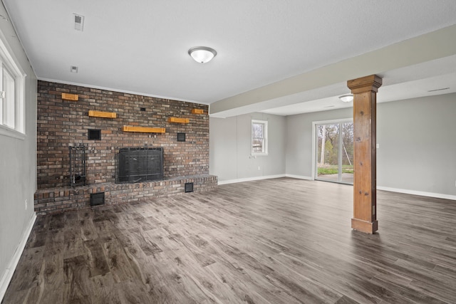 unfurnished living room with visible vents, baseboards, and wood finished floors