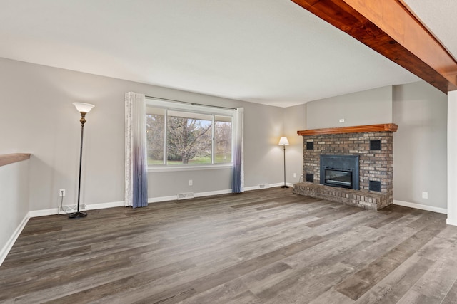 unfurnished living room featuring a brick fireplace, wood finished floors, visible vents, and baseboards