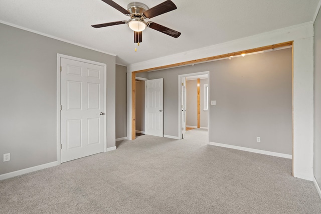 unfurnished bedroom with carpet, crown molding, and baseboards