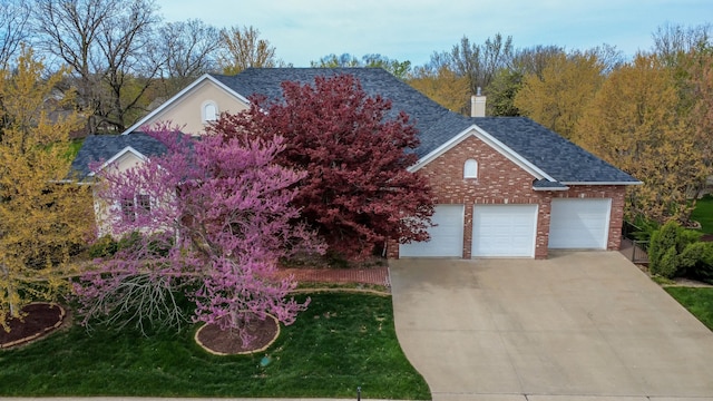 traditional-style home with concrete driveway, a chimney, roof with shingles, and a garage